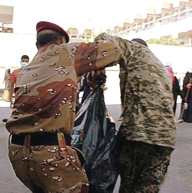 جنديان من الحرس والفرقة يتعاونان في حمل كيس قمامة (صورة مؤثرة)