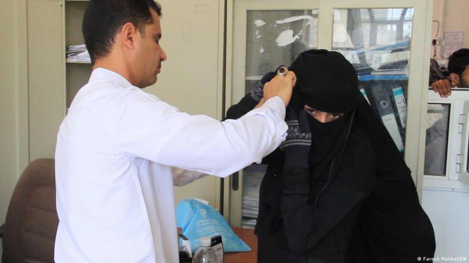 طبيب يفحص يمنية متضررة من ضعف السمع